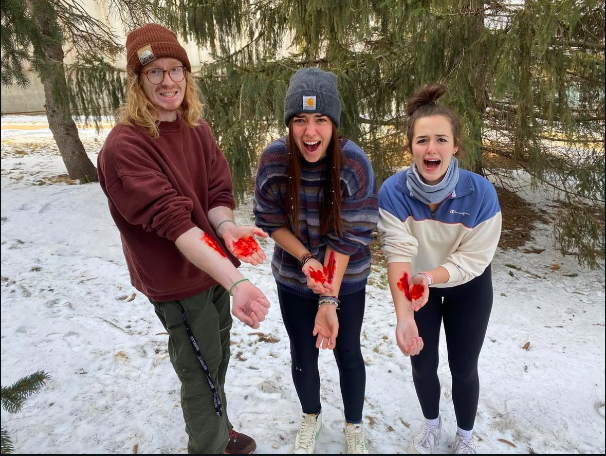 Three people holding out fake bloody arms